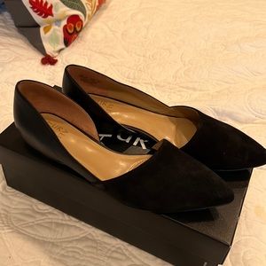 Black flats have suede and leather